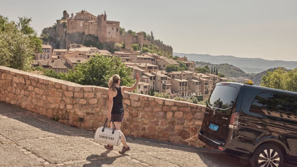 Una viajera del Bus del Vino fotografía Alquézar junto a la furgoneta
