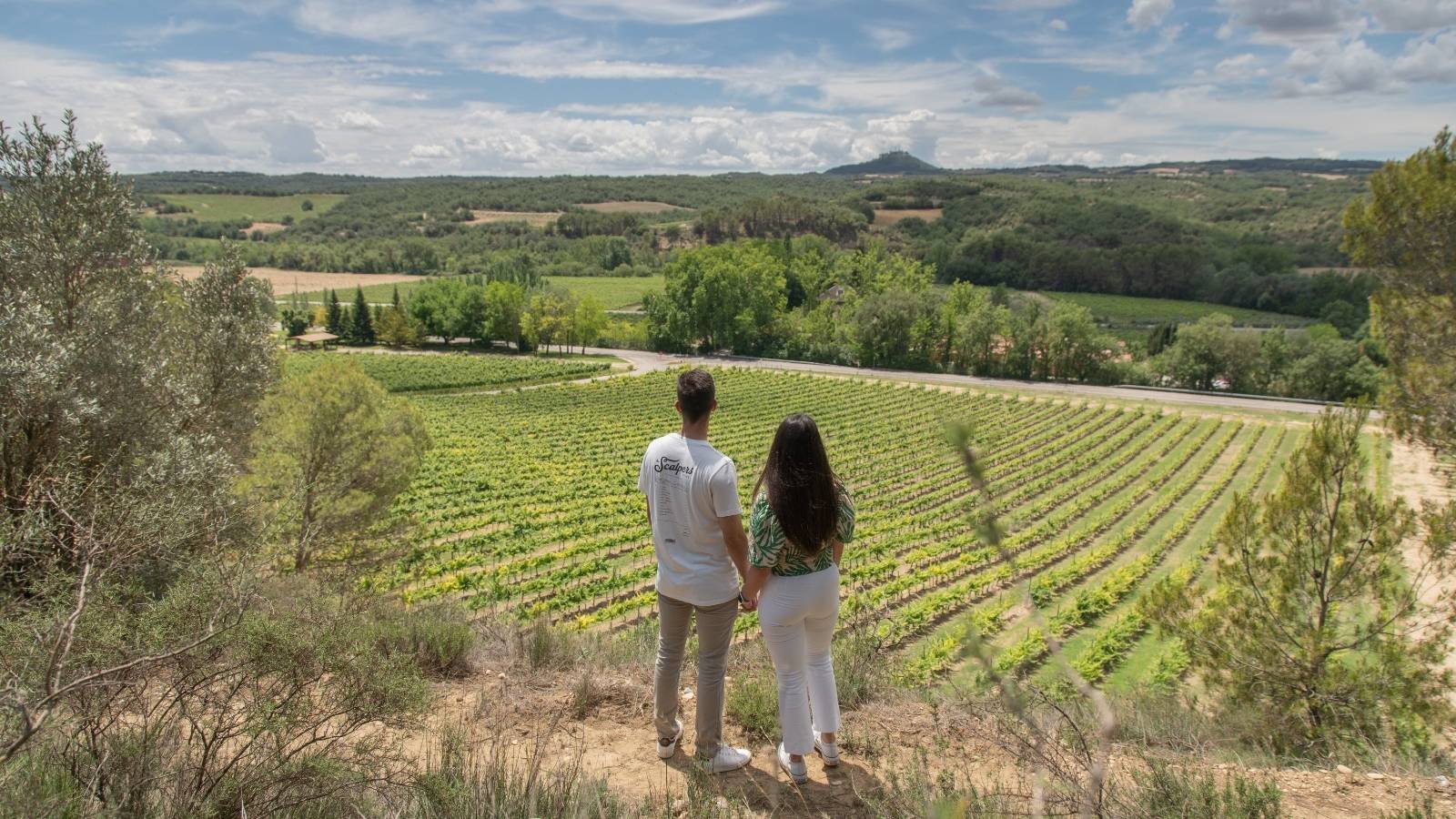 Una pareja mira los viñedos del Somontano desde un alto